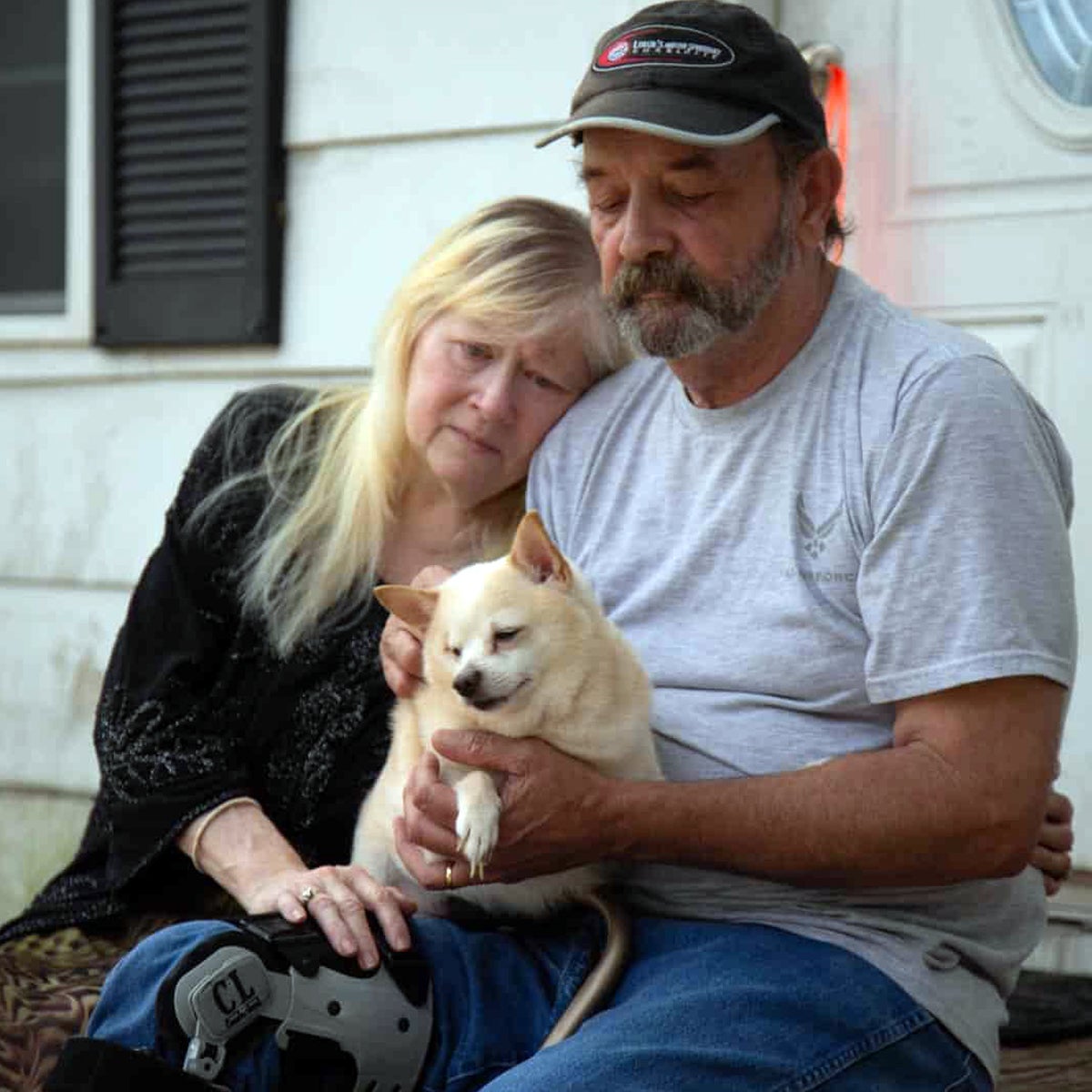 John, Crystal, and their dog sit on the porch of their flooded home. Miracles surround their escape from Hurricane Florence.