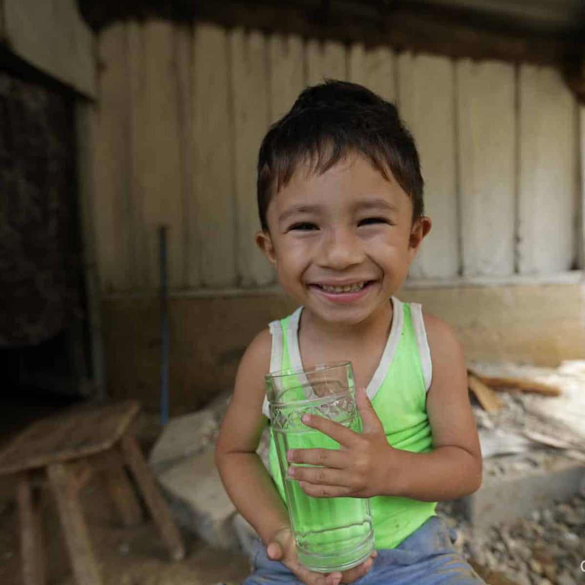 A young boy holds a water cup. Operation Blessing brings life to dry places.