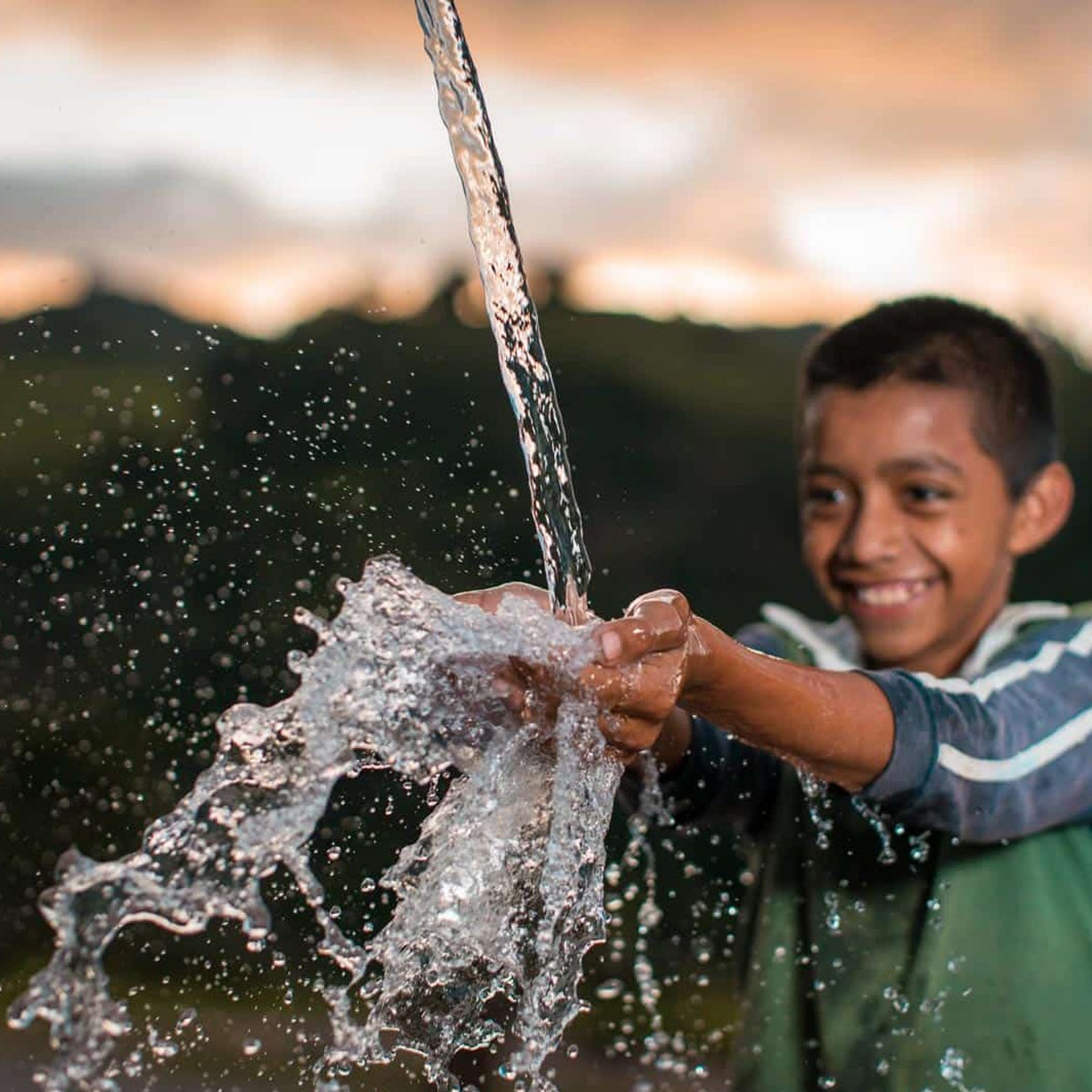 A boy splashing in fresh, clean water.