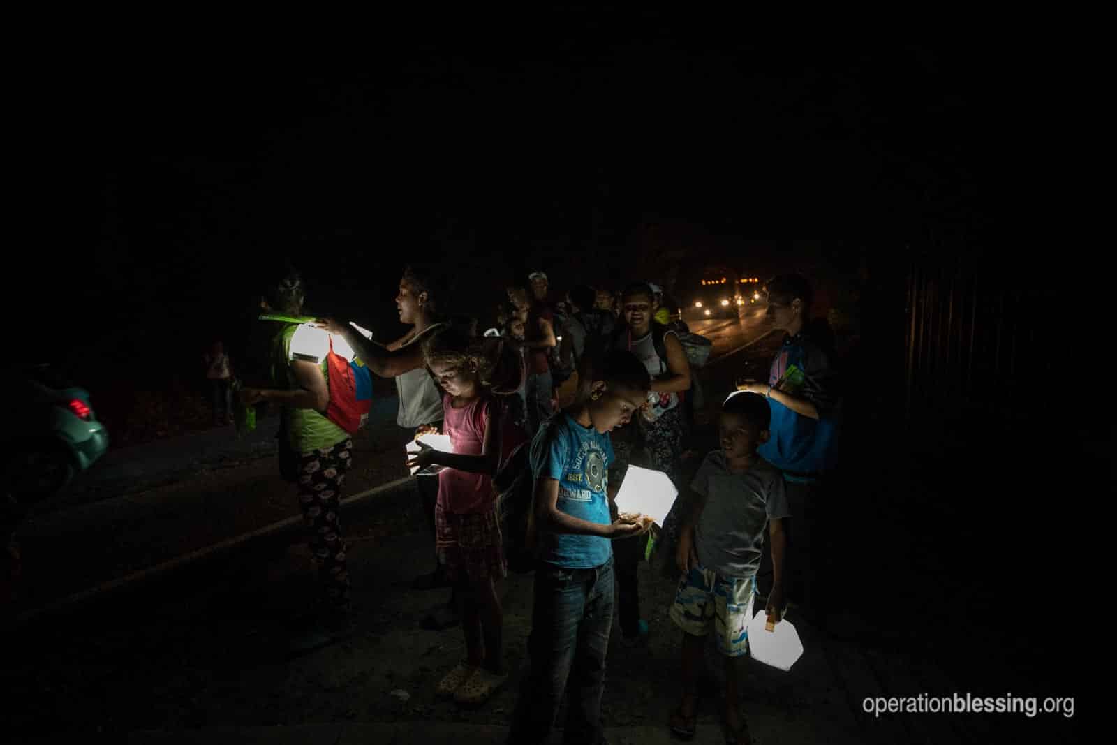Venenzuelan refugees receive solar lights from Operation Blessing along a dangerous road.