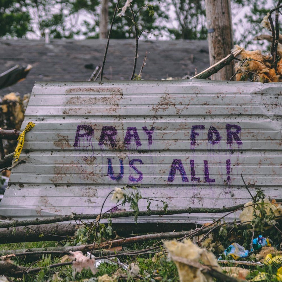 A sign in the rubble of the Dayton Tornado saying, "Pray for us all."