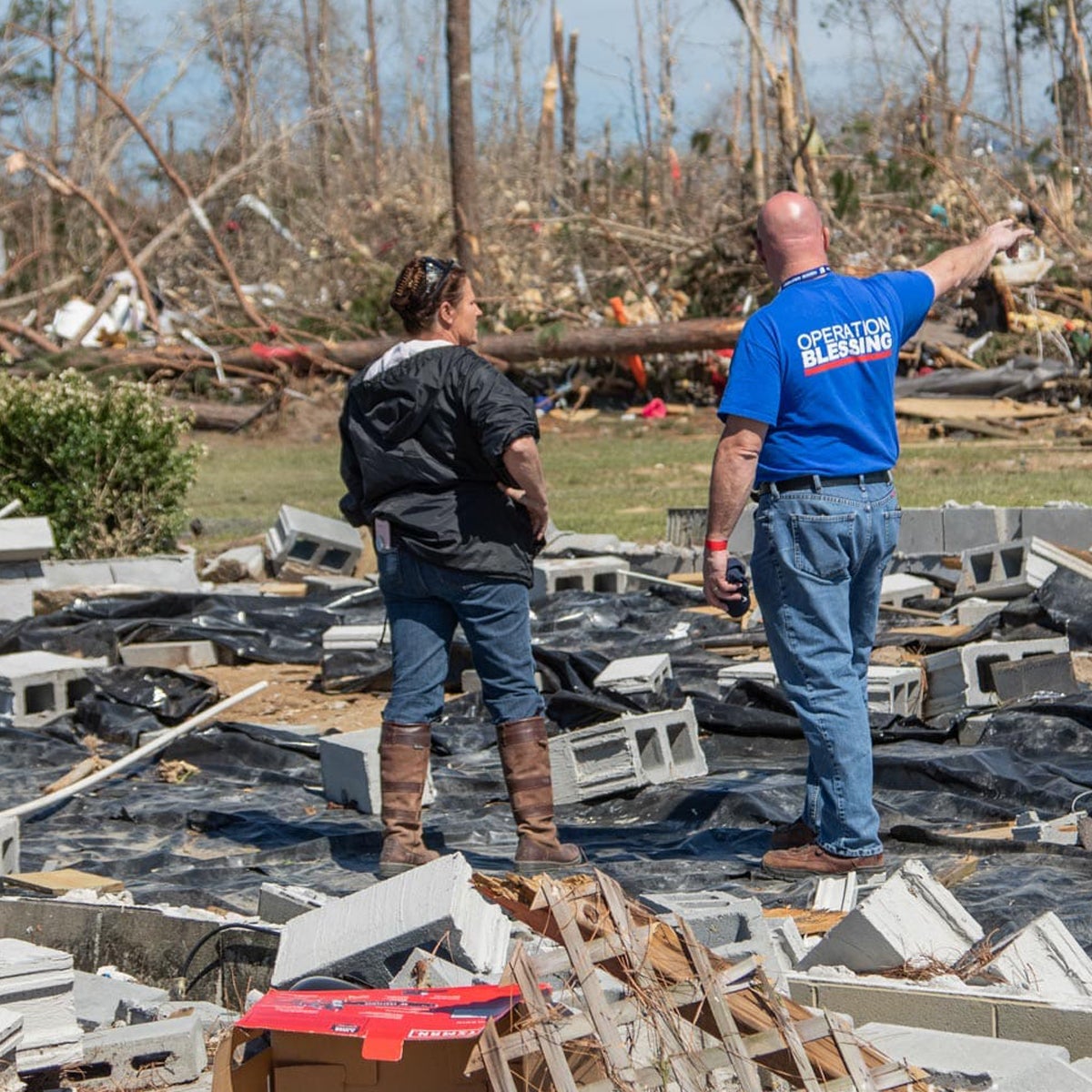 An Operation Blessing worker helps a tornado victim. A disaster preparedness kit is helpful in these situations.
