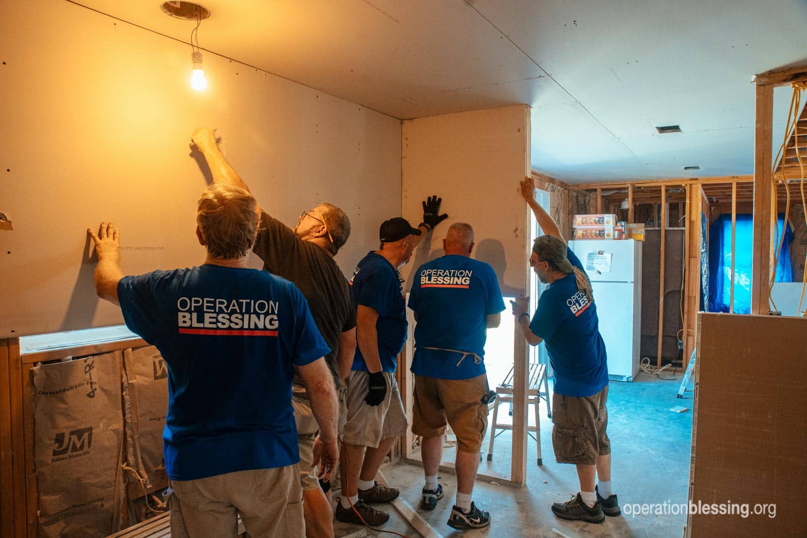 The whole Operation Blessing volunteer crew installing drywall.