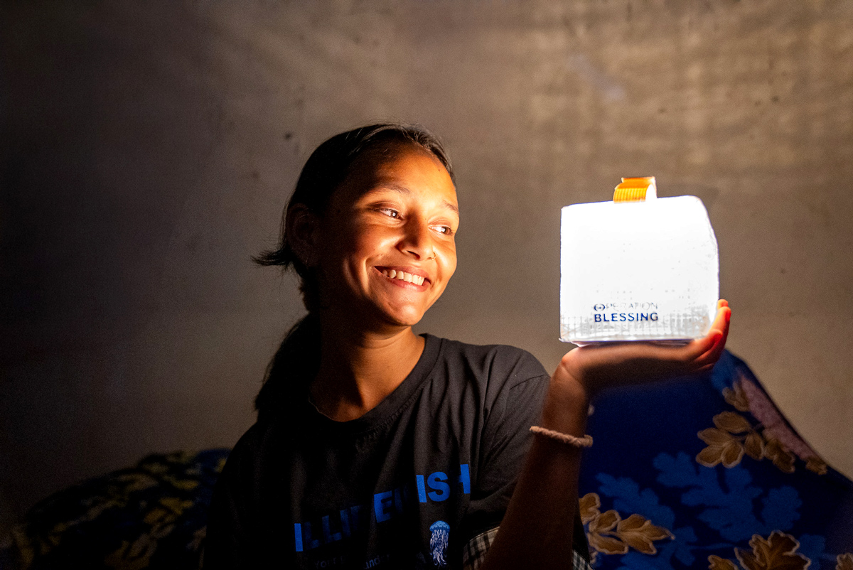 Image of woman in Nepal holding a lantern.