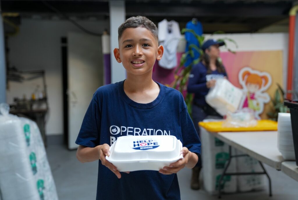 Child helping with meals following Colombia earthquake.