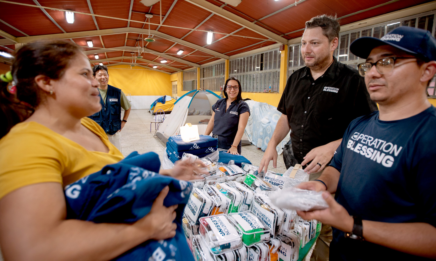 Woman receiving clothes and food from Operation Blessing volunteers